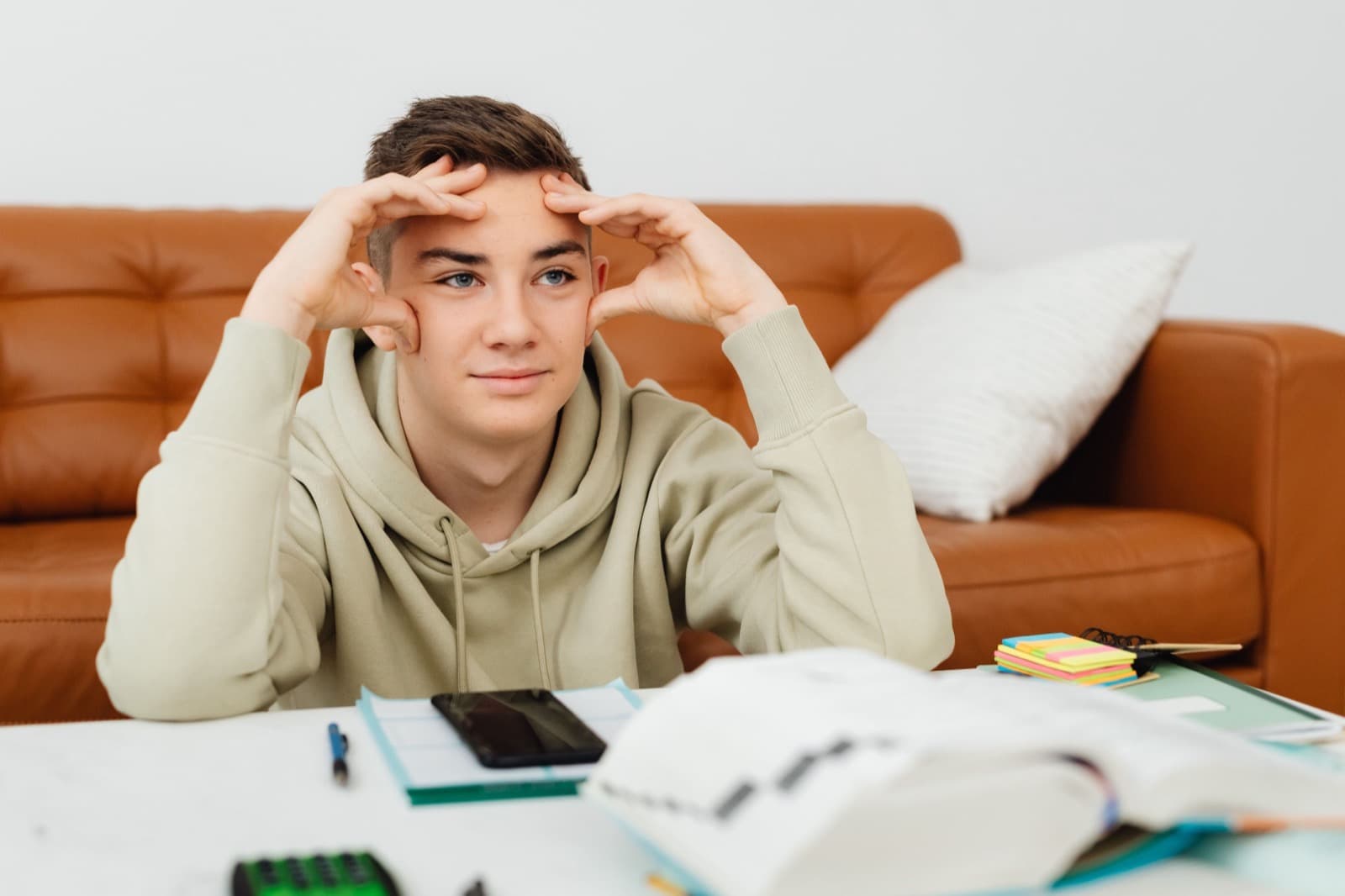 A teenager at a desk of schoolwork